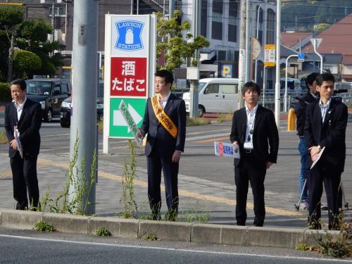 交通街頭キャンペーンでプラカードを手に道路わきに立つ市長らの写真