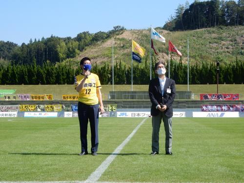 松江シティFCのユニフォームを着た市長がマイクで挨拶している様子の写真