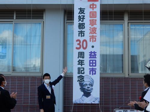 掲揚した懸垂幕と市長の写真