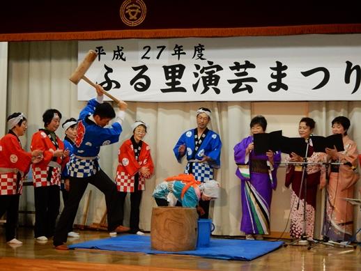 ステージ上で餅つきの杵をつく市長とそれを見守る人たちの様子の写真