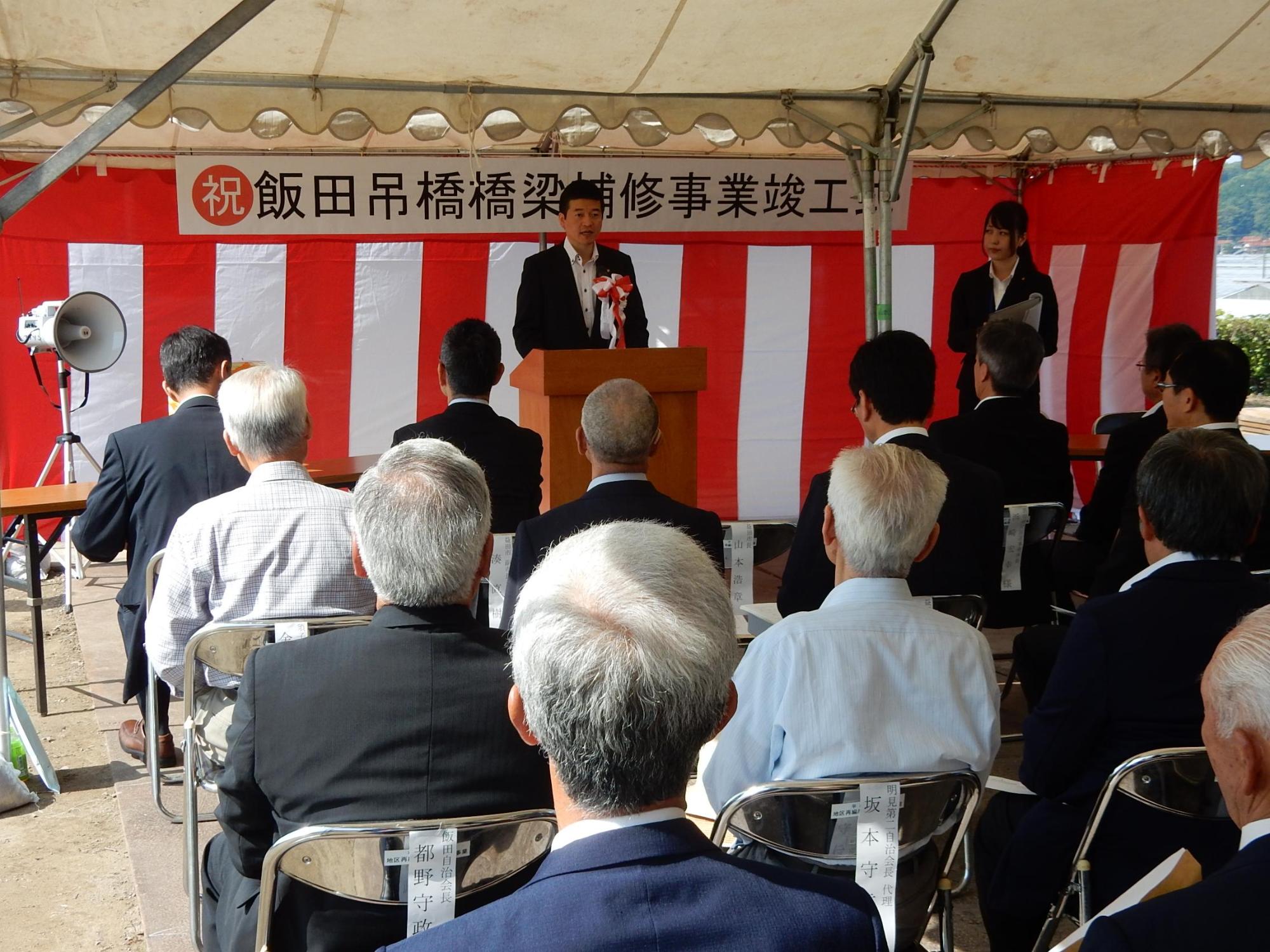 飯田吊橋橋梁補修事業竣工式にて挨拶をする市長の様子の写真