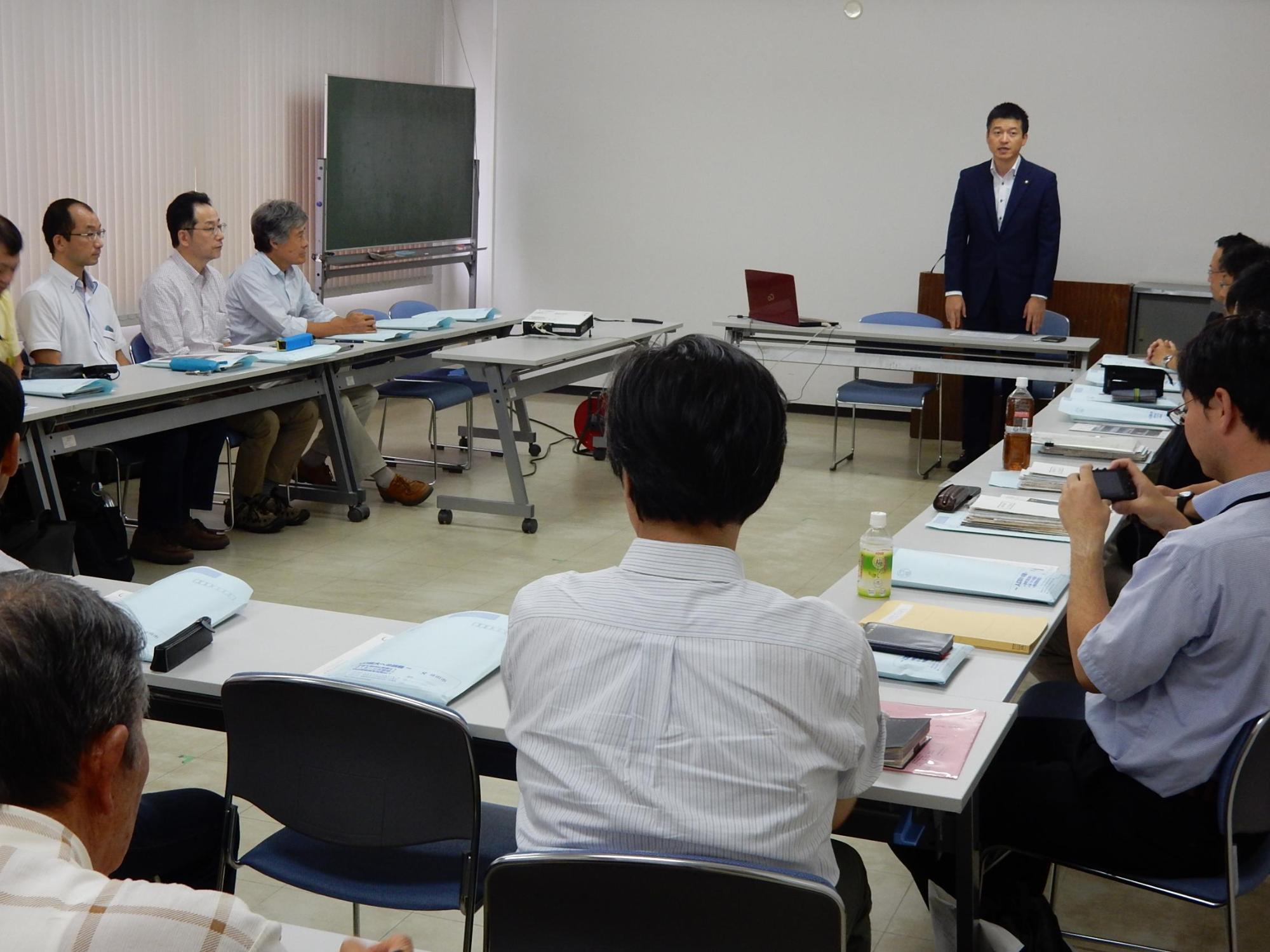 国立歴史民俗博物館共同研究会の集まりで言葉を述べる市長と傾聴する参加者らの写真