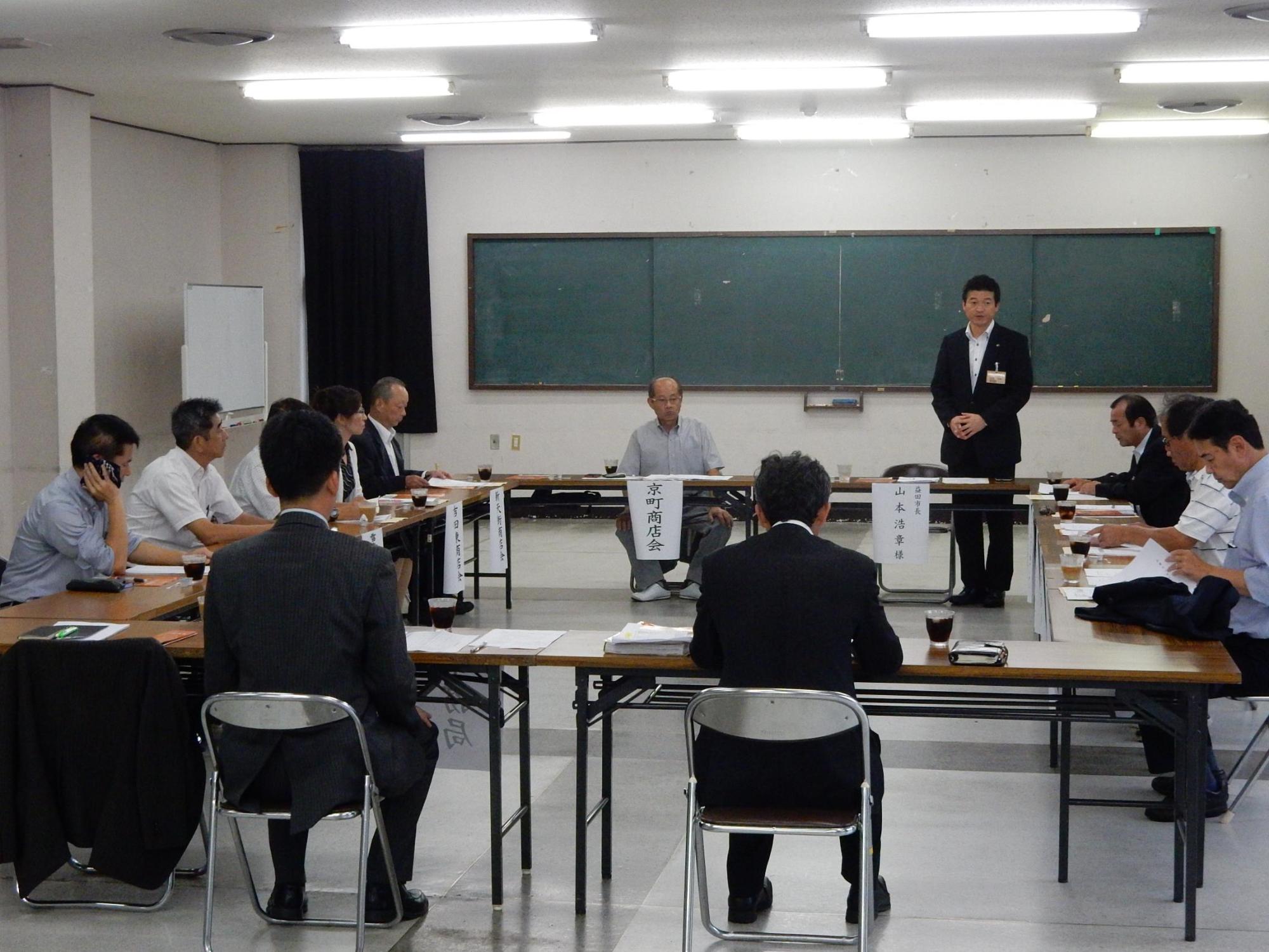 益田市商店会連合会懇談会にて言葉を述べる市長と傾聴する参加者らの写真