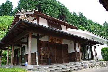 瓦屋根と木の縦格子の玄関が歴史を感じる秦記念館概観の写真